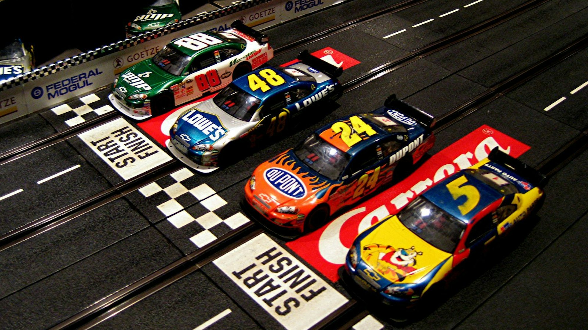 Vier Carrera-Autos auf der Bahn.