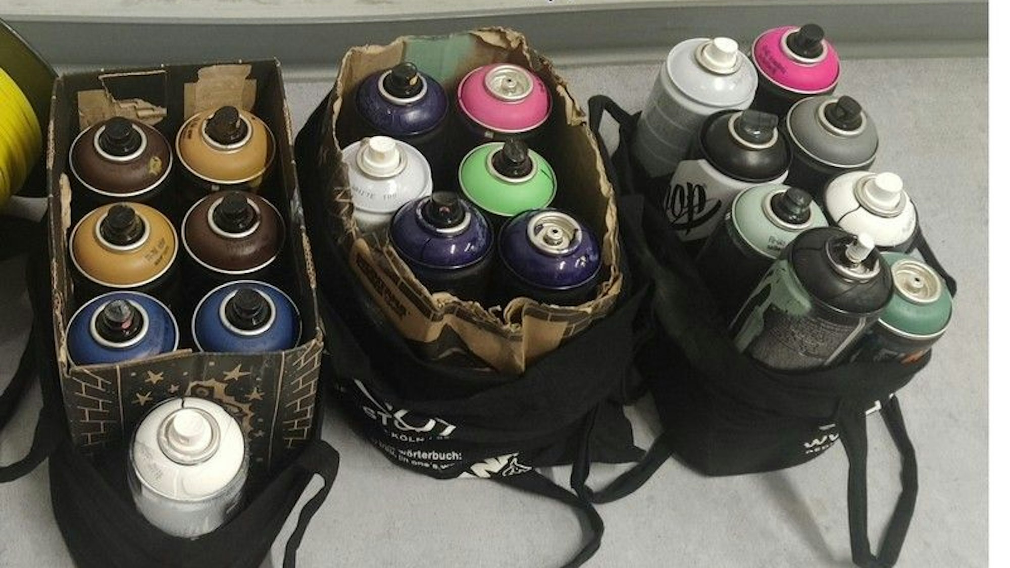 14 Sprühdosen in Kartons und Taschen.