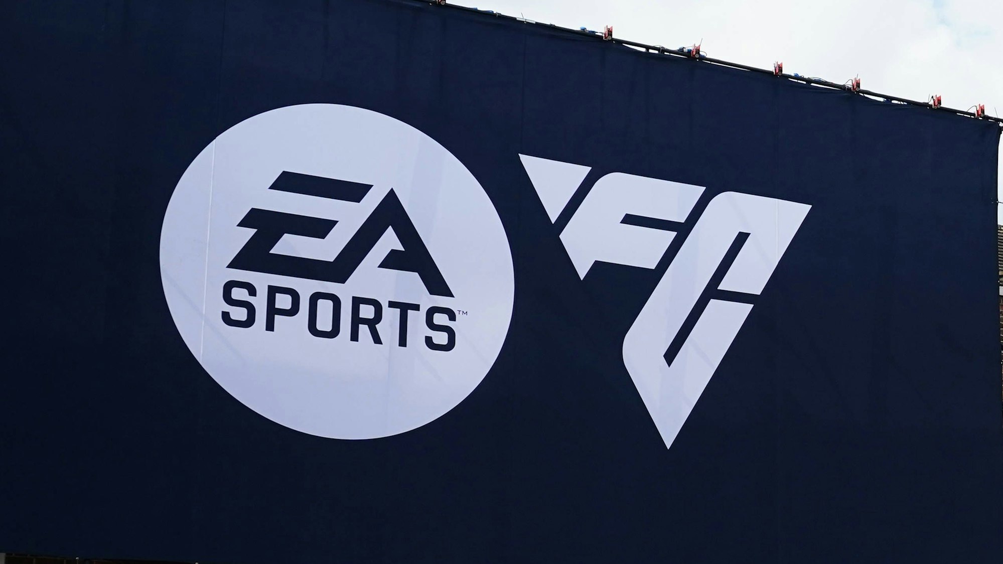 Das Logo von EA Sports und das Logo von EA Sports FC auf einem Werbeplakat.