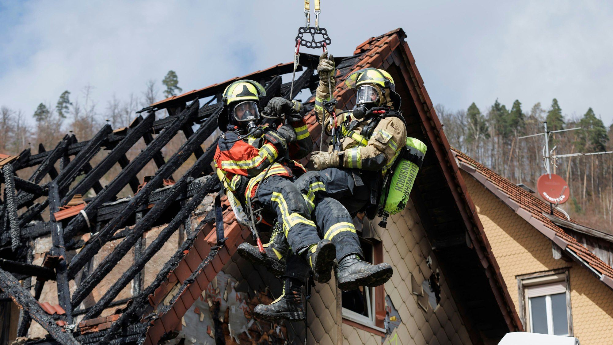 Zwei Feuerwehrleute bei der Bergung des Hausbrandes in Gernsbach