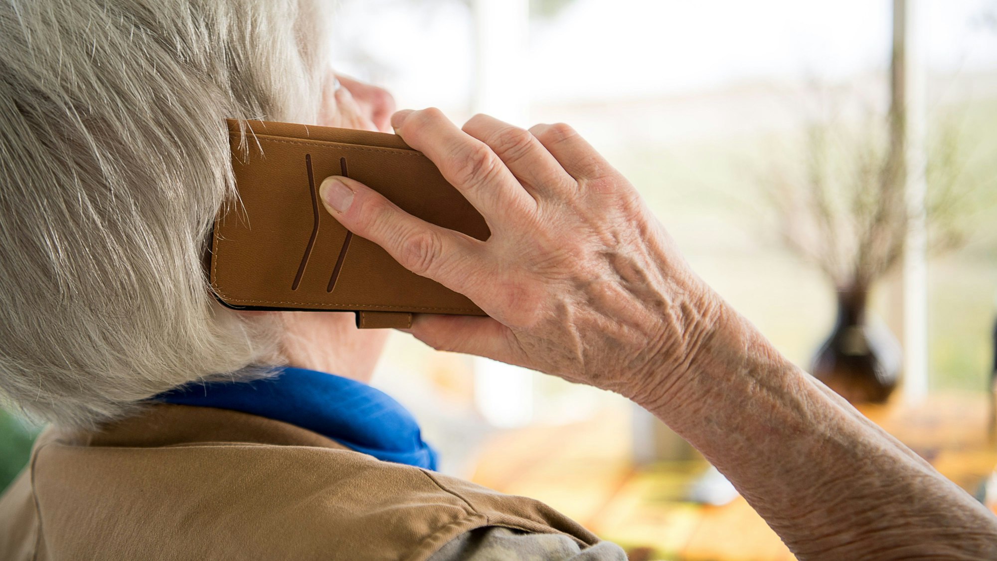 Eine Seniorin telefoniert mit ihrem Smartphone.