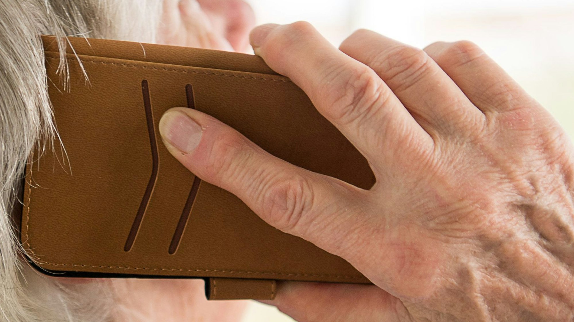 ARCHIV - 06.03.2018, Baden-Württemberg, Mühlacker: Eine Seniorin telefoniert mit ihrem Smartphone (zu dpa «Schockanrufe und WhatsApp-Enkeltrick bringen Opfer um Millionen»). Foto: Sebastian Gollnow/dpa +++ dpa-Bildfunk +++