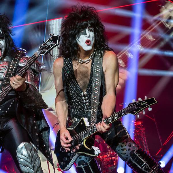 Gene Simmons und Paul Stanley von der US-amerikanischen Hard-Rock-Band Kiss bei einem Auftritt auf der Bühne. Sie halten E-Gitarren in der Hand.