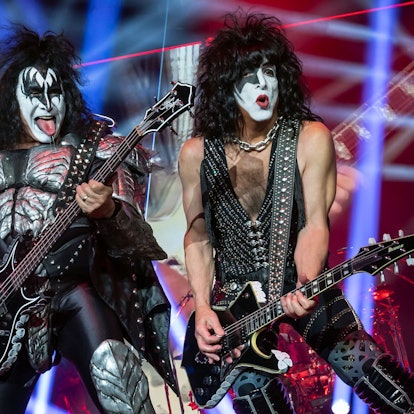 Gene Simmons und Paul Stanley von der US-amerikanischen Hard-Rock-Band Kiss bei einem Auftritt auf der Bühne. Sie halten E-Gitarren in der Hand.
