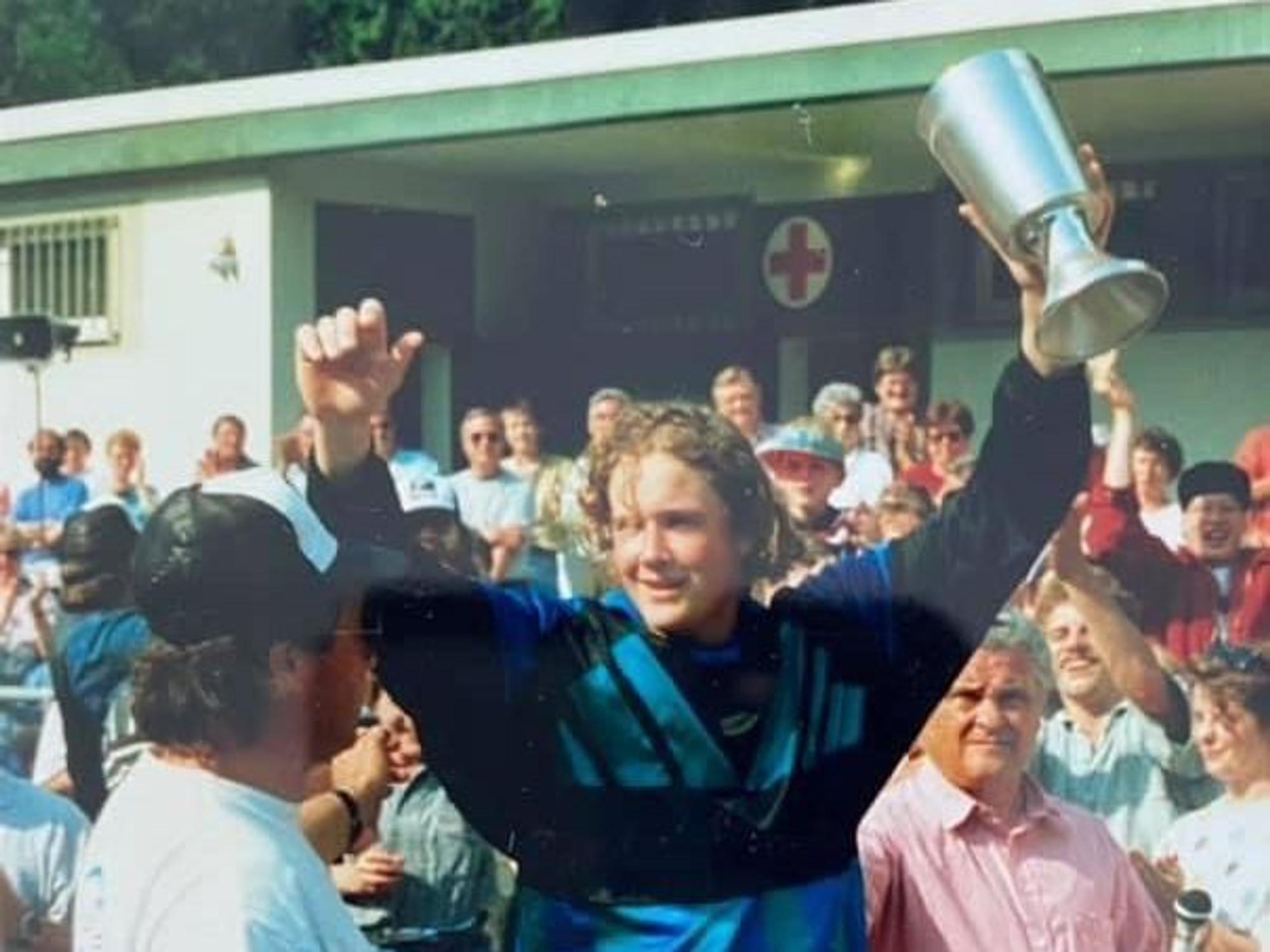 Zu sehen ist ein Torwart, der einen Pokal in der Hand hält und jubelt.