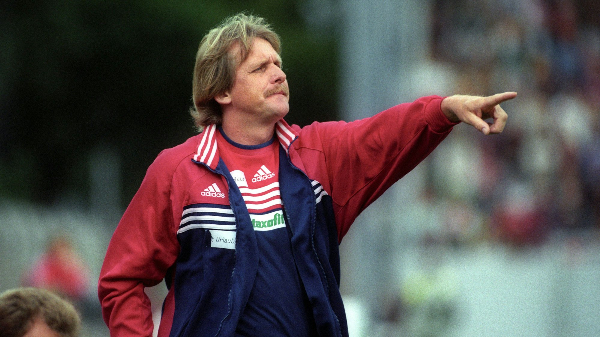 FC-Trainer Bernd Schuster steht im Trainingsanzug am Spielfeldrand und gibt gestikulierend Anweisungen an seine Spieler.