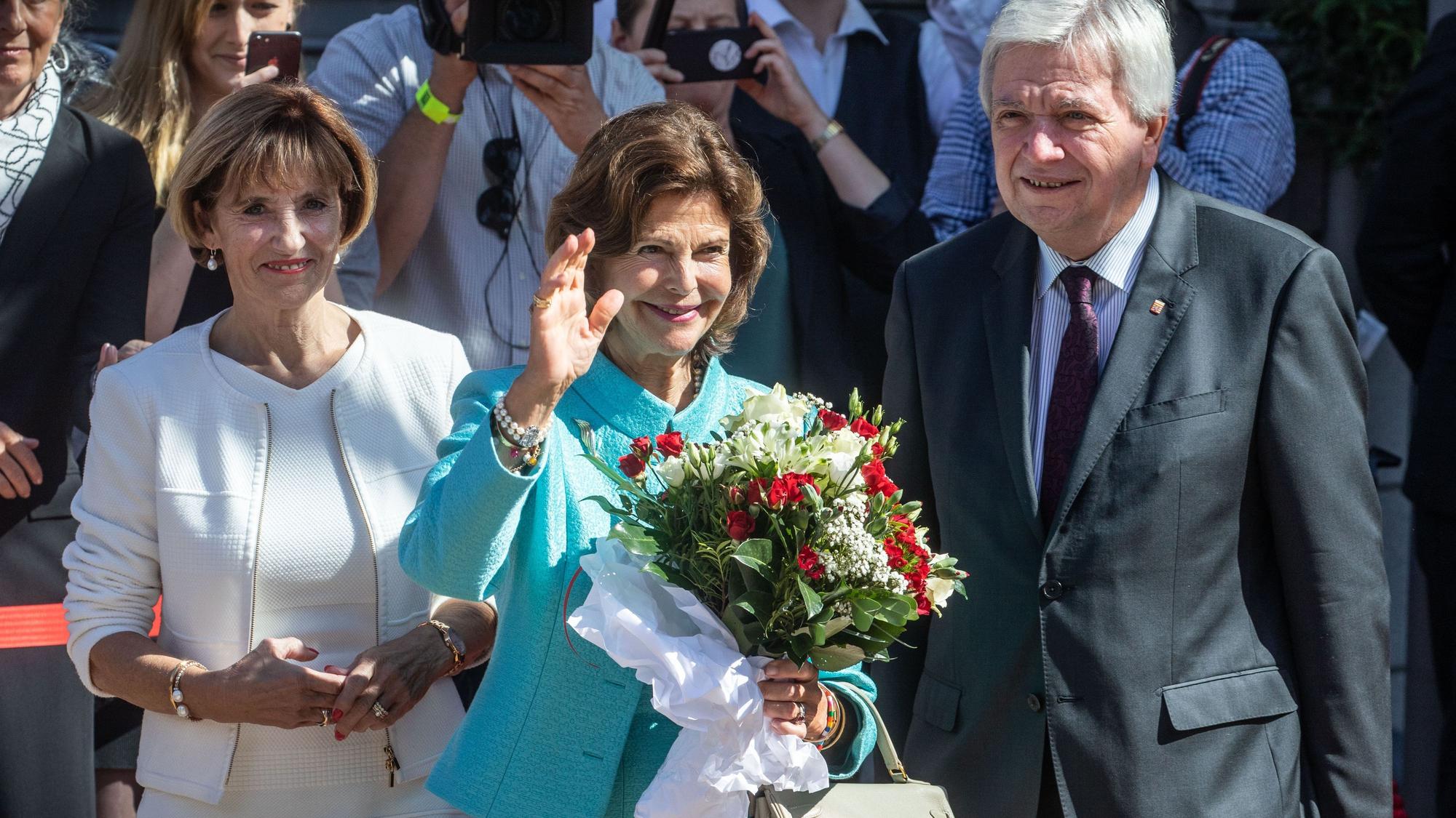Königin Silvia von Schweden winkt den Zuschauern, während sie vor der Hessischen Staatskanzlei vom hessischen Ministerpräsidenten Volker Bouffier und dessen Frau Ursula empfangen wird.