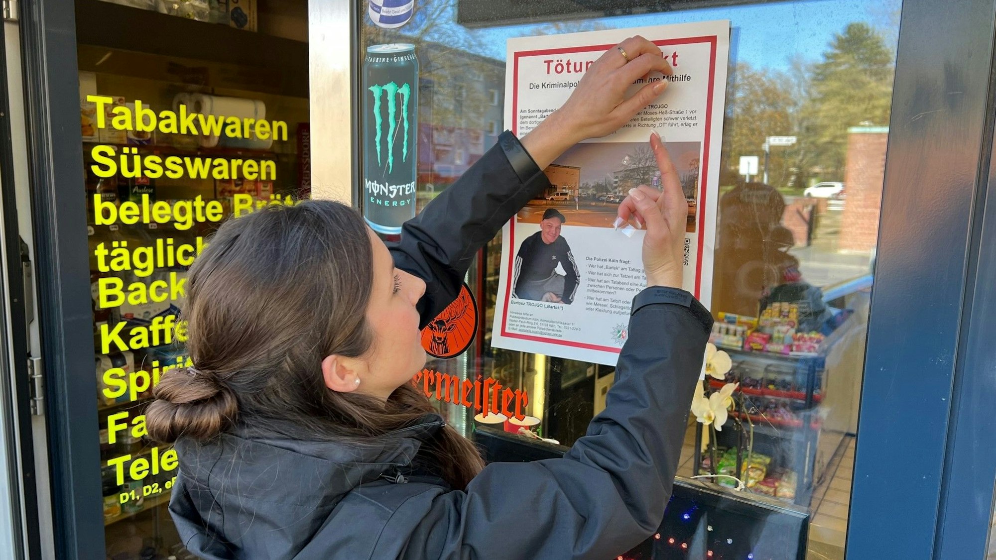Hauptkommissarin Ramona Breuer, Leiterin der Mordkommission, klebt ein Fahndungsplakat an den Kiosk in Stammheim, wo Bartek Trojgo am 12. März 2023 niedergestochen wurde.