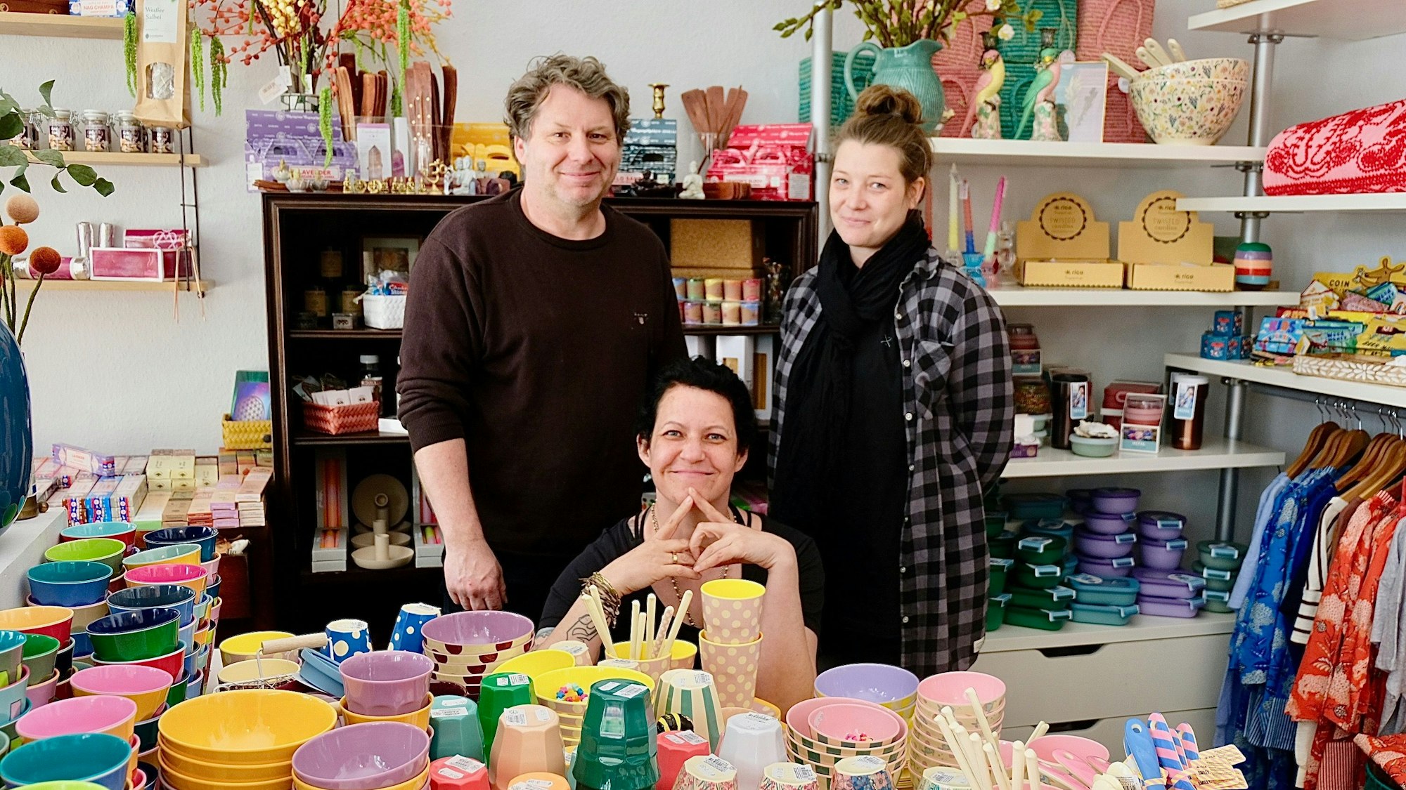 Die drei Betreiber des Ladens vor einem Tisch aus Porzellan.