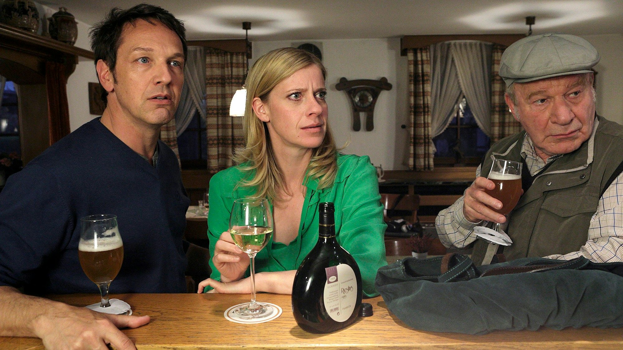 Sophie Haas (Caroline Peters, M.) trifft sich mit Andreas Zielonka (Max Gertsch, l.) und dessen Vater Hans (Michael Hanemann, r.) im Gasthof.