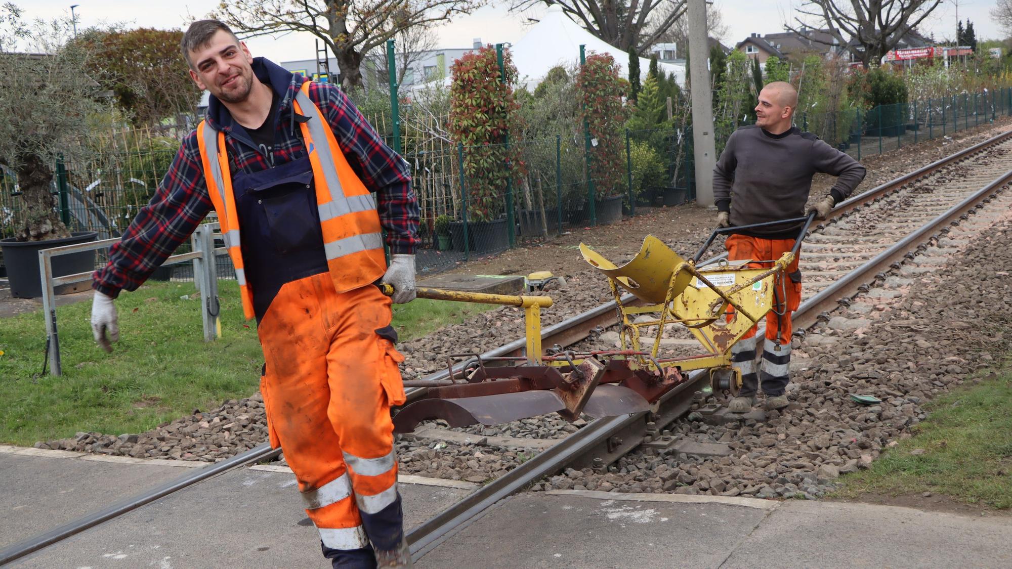 Das Foto zeigt, wie Bauarbeiter nach Abschluss der Arbeiten an der Bahnstrecke zwischen Brühl und Bornheim Material wegräumen.