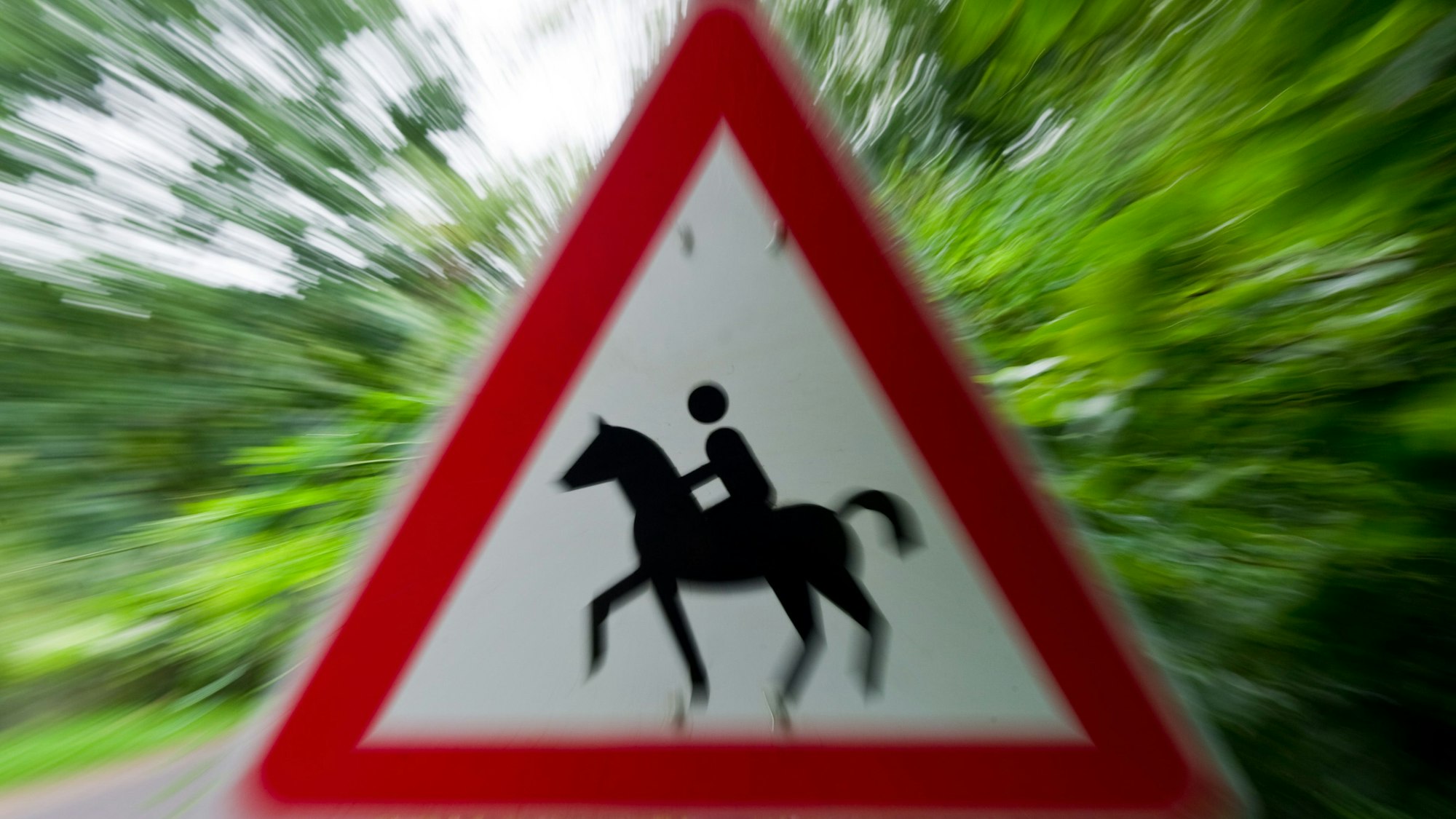 Ein Achtung Reiter-Schild an einer Straße.