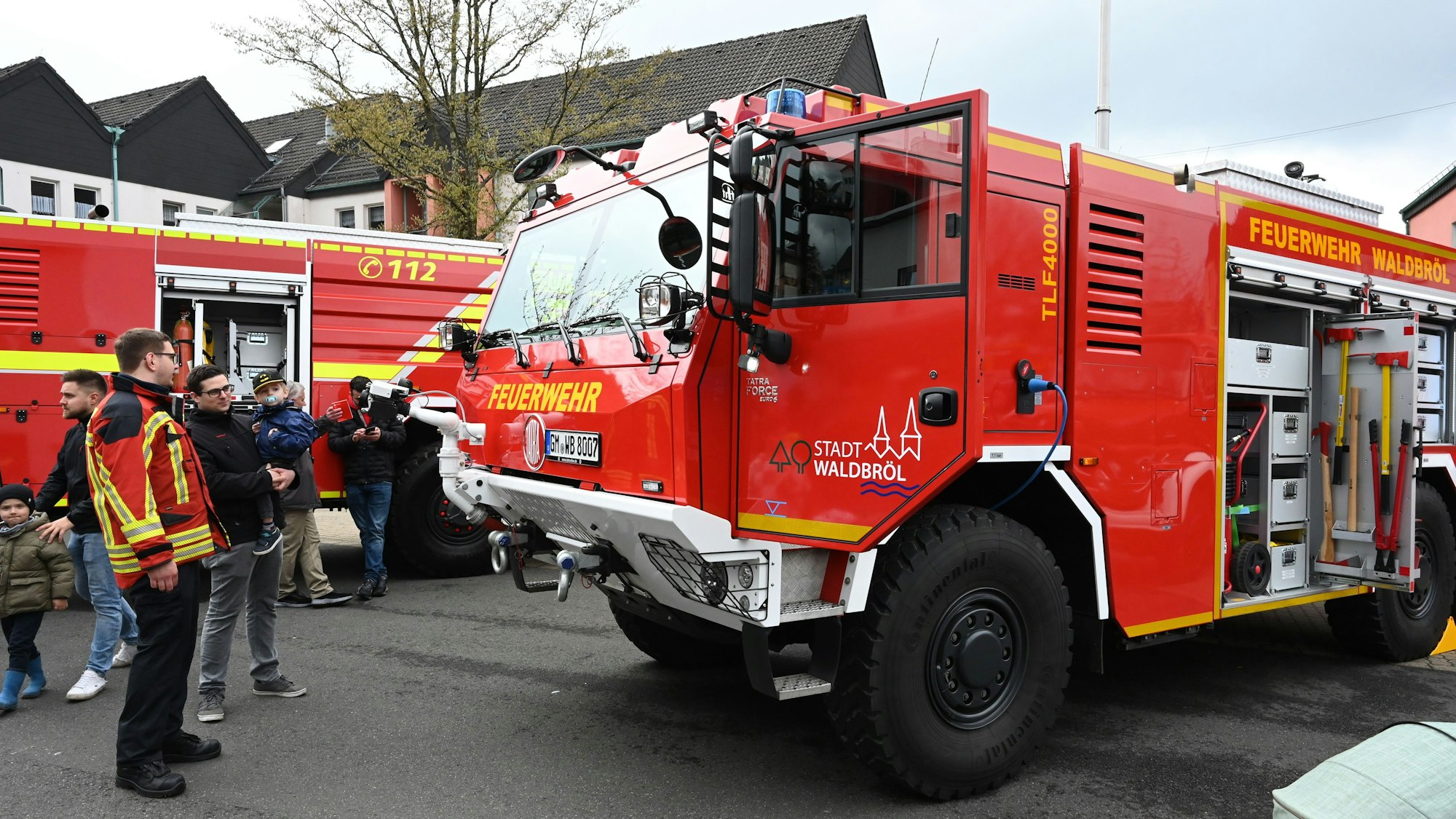 Ein Feuerwehrmann erklärt einem Besucher die Ausstattung eines Feuerwehrautos.