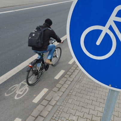 Ein Mann fährt mit seinem Fahrrad auf einem mit einem Verkehrsschild gekennzeichneten Radweg.