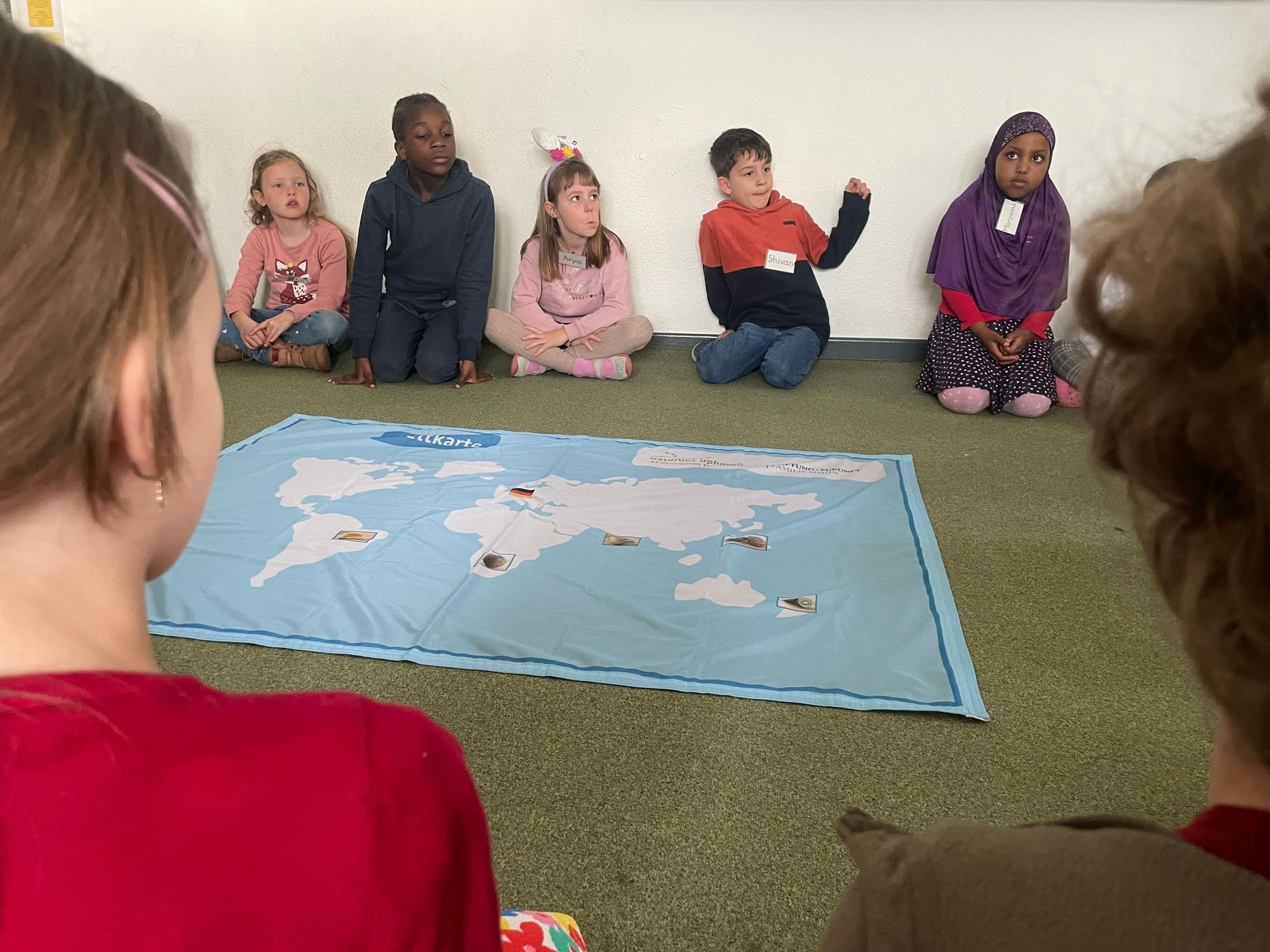 Kinder erfahren anhand einer Weltkarte, woher Früchte aus aller Welt nach Deutschland transportiert werden, damit wir sie hier kaufen können.