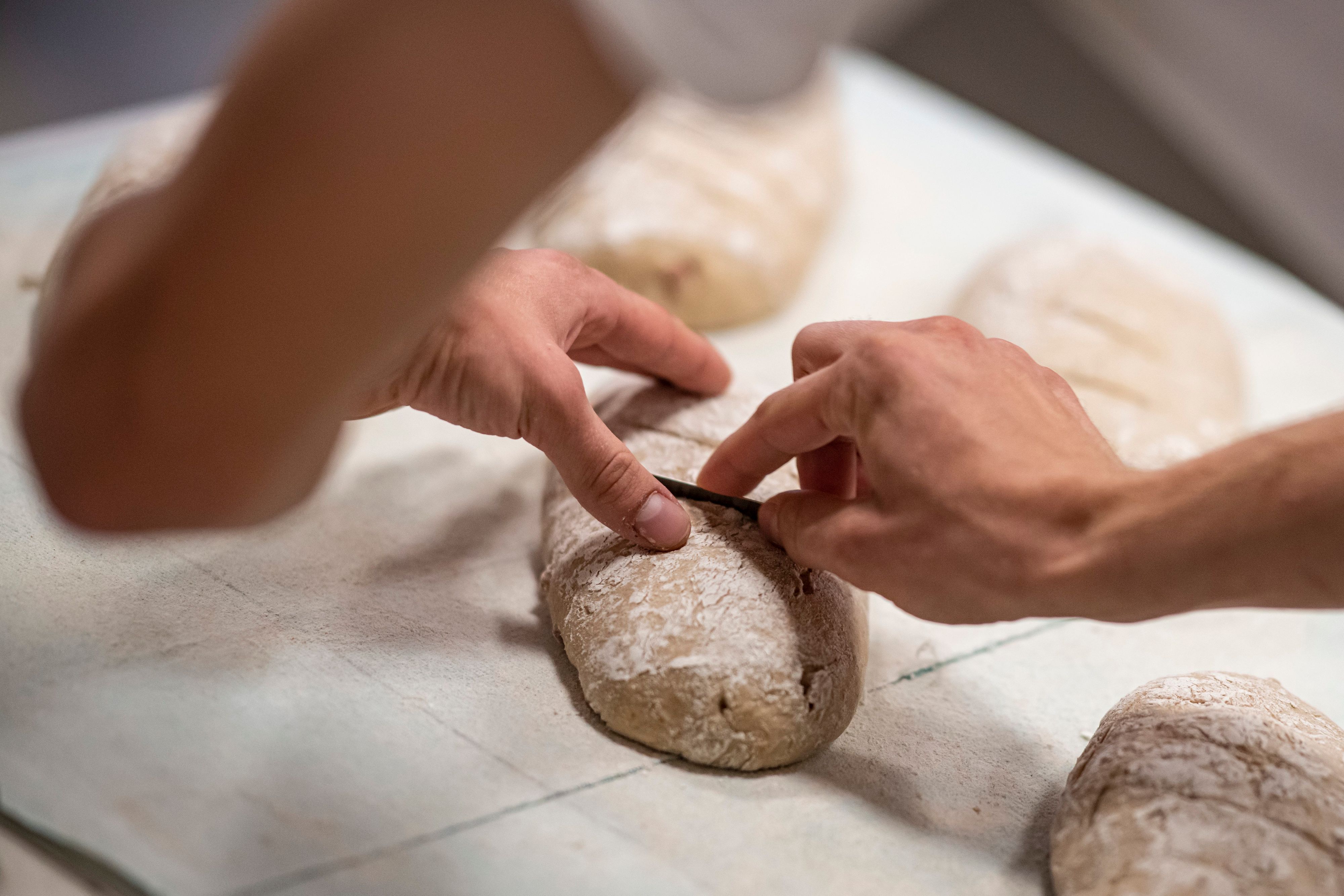 Eine Person arbeitet an einem Brot.