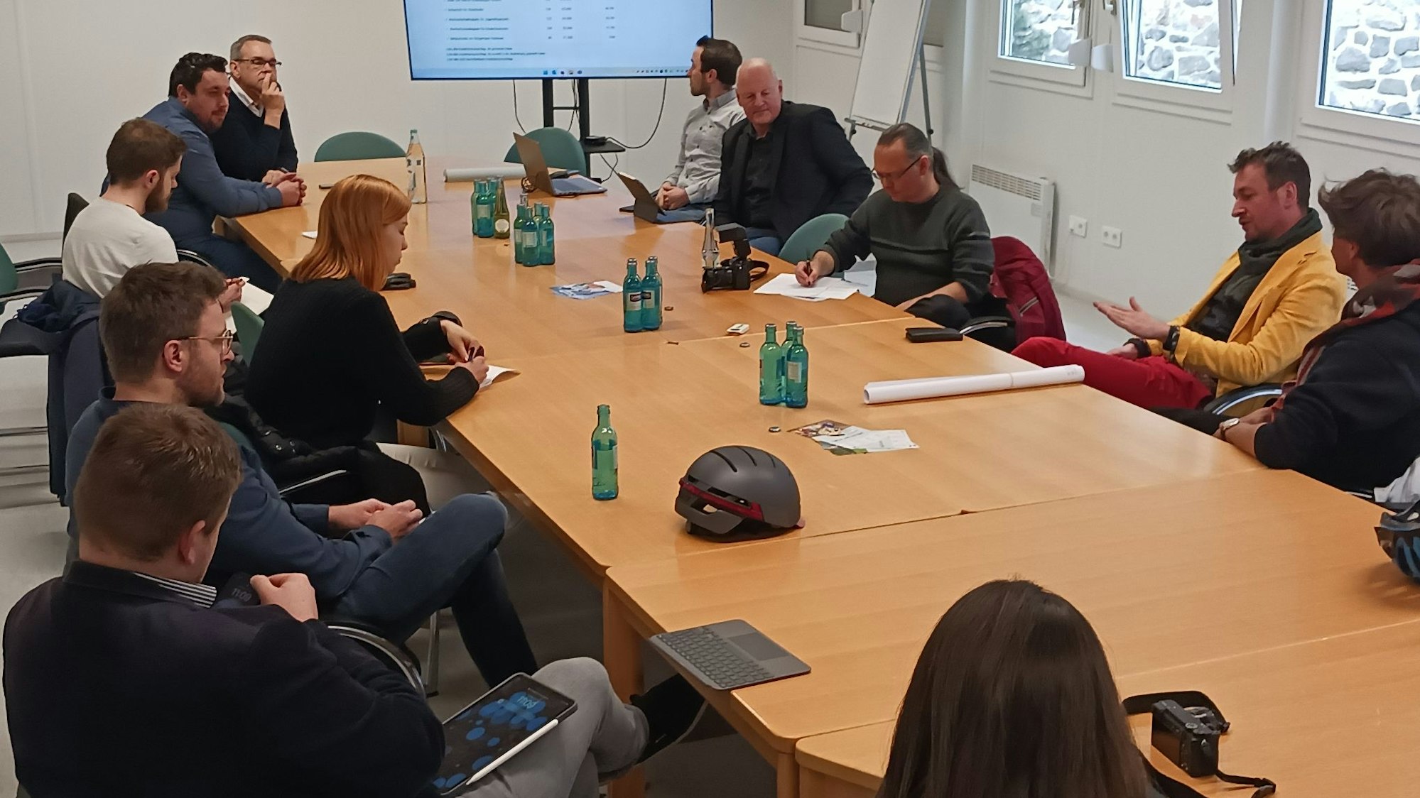 Menschen sitzen an einem Tisch und diskutieren.