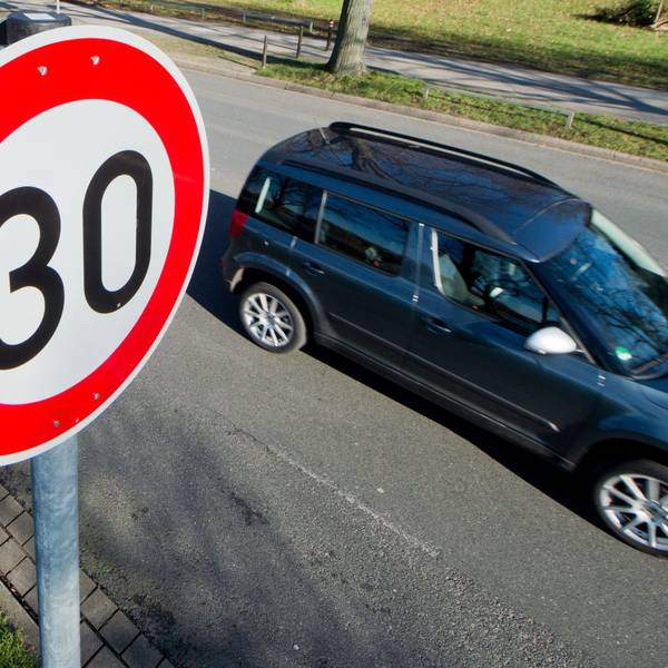 Ein Auto fährt an einem Verkehrsschild für eine Geschwindigkeitsbegrenzung von 30 Stundenkilometern vorbei.
