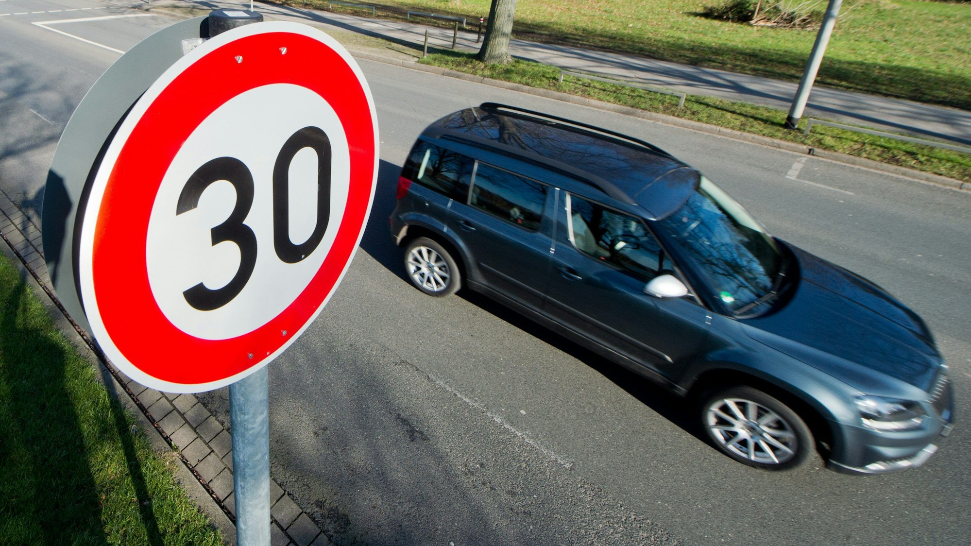 Ein Auto neben einem Tempo-30-Schild.