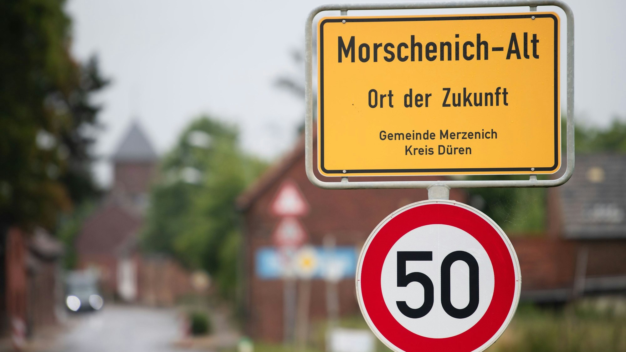 21.07.2022, Nordrhein-Westfalen, Morschenich: Das Ortseingangsschild von Morschenich-Alt. Der kleine Ort Morschenich am Tagebau Hambach sollte den Braunkohlebaggern weichen. Doch dieses Vorhaben wurde aufgeben. Jetzt wollen die Planer dem schon fast verwaisten Ort neues Leben einhauchen