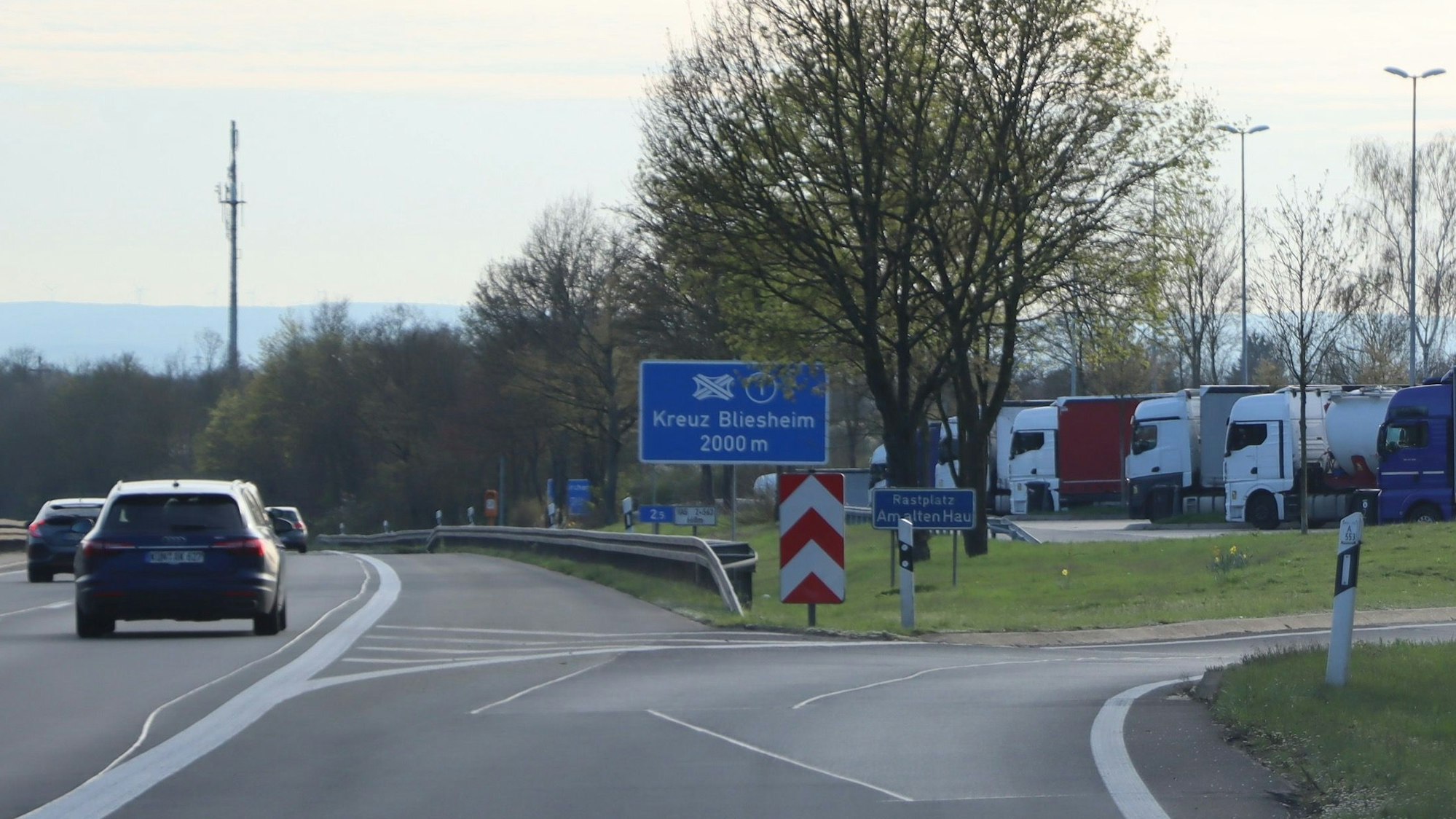 Auf dem Foto ist die Abfahrt zum Rastplatz „Am alten Hau“ zu sehen. Er ist ein beliebter Treffpunkt für Homosexuelle. Um ungestört zu sein, schneiden sie Zäune auf, durch die allerdings Wildschweine auf die Autobahn gelangen können.