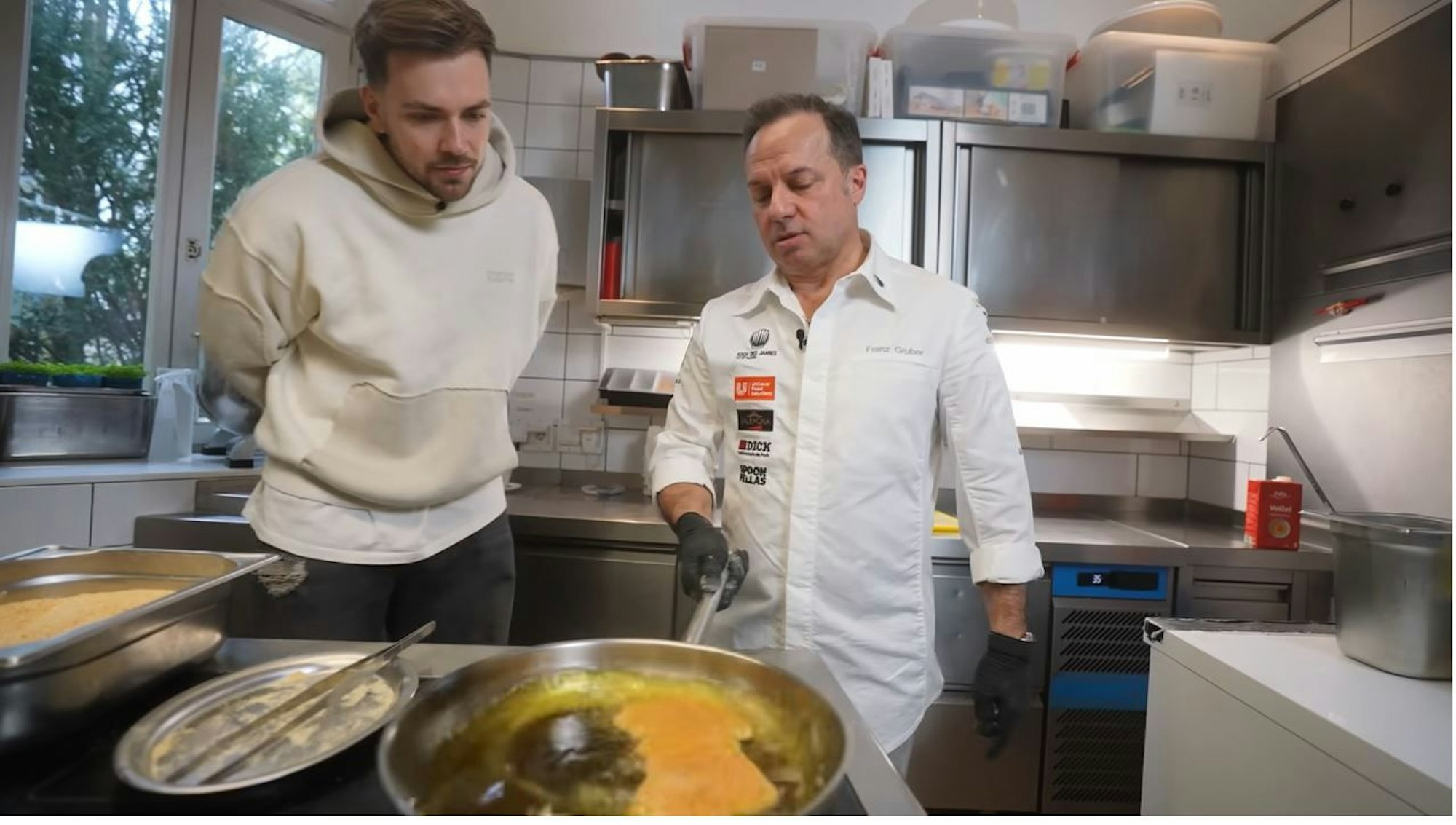 Max und Franz Gruber stehen am Herd und braten Schnitzel