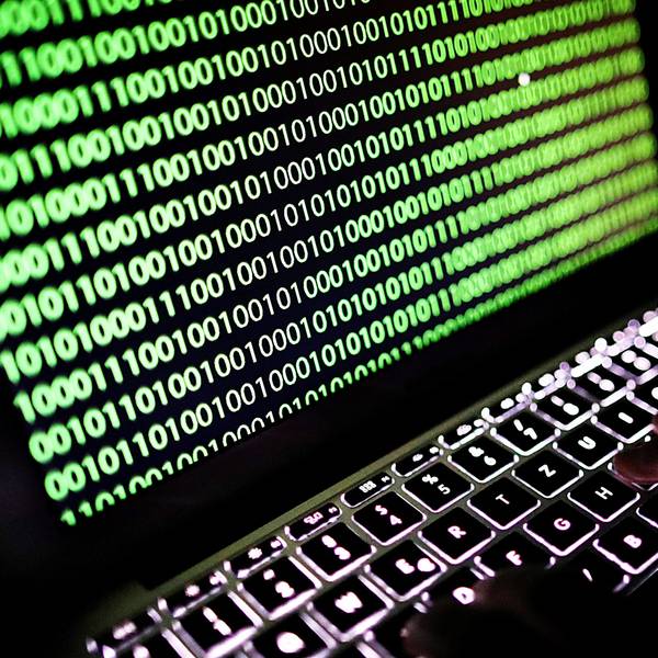 Auf dem Bildschirm eines Laptops ist ein Binärcode zu sehen.