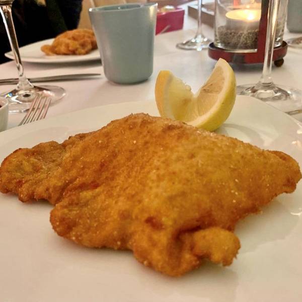 Ein Schnitzel liegt auf einem Teller
