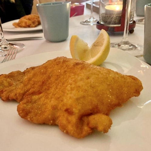 Ein Schnitzel liegt auf einem Teller