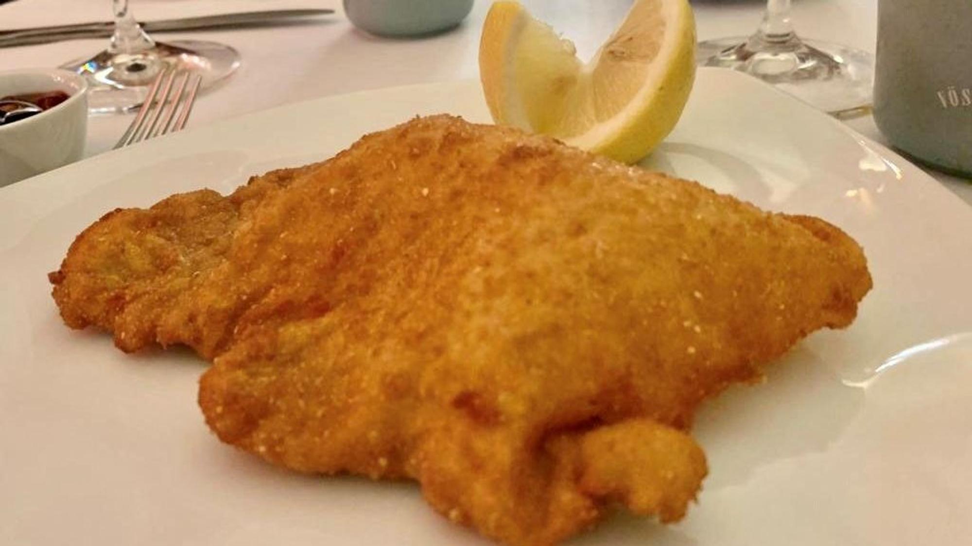 Ein Schnitzel liegt auf einem Teller