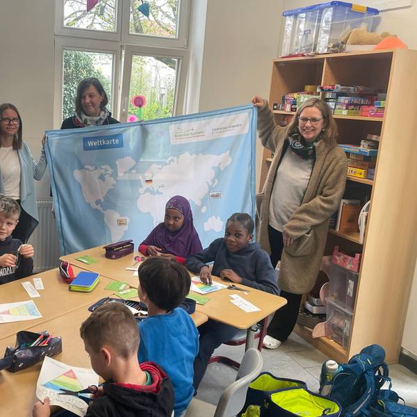 Annette Beggerow (Stiftung Simon), Ursula Pauli (Ernährungsexpertin Naturgut Ophoven) und Ute Pfeiffer-Frohnert (Leiterin Kinder- und Jugendmuseum Energiestadt) vor Schülern der GGS Opladen.