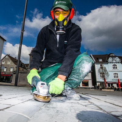 Ibrar Zaki schleift die Steine des Wipperfürther Marktplatzes ab.