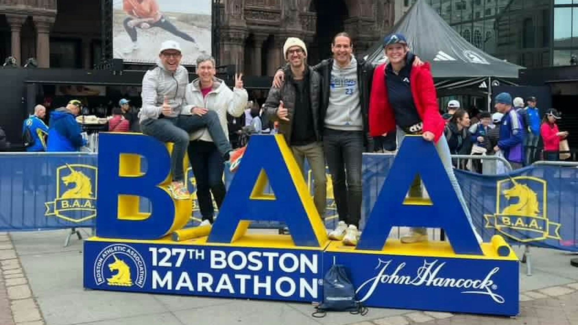 Jörg Löhr und Begleiter vor dem Schild des Boston Marathon
