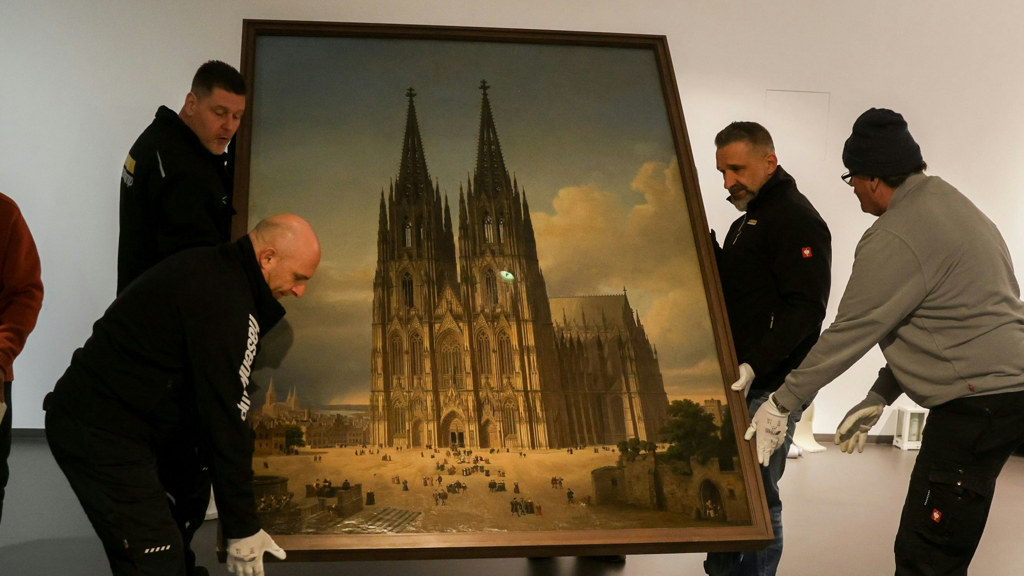 Bild des Kölner Doms, welches von vier Männern getragen wird.