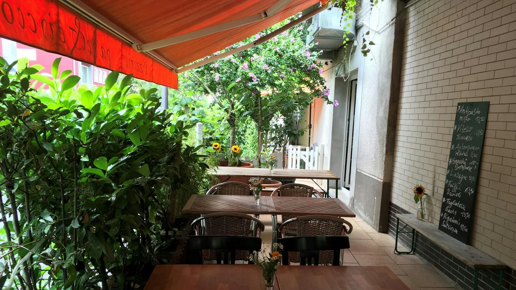 Terrasse mit Markise und Holzmöbeln.