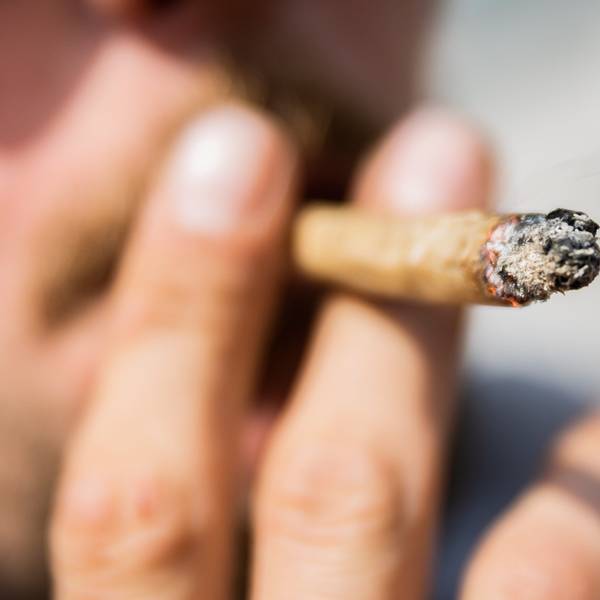 Ein Mann raucht bei einer Demonstration für eine zügige Legalisierung von Cannabis einen Joint mit Medizinalcannabis.
