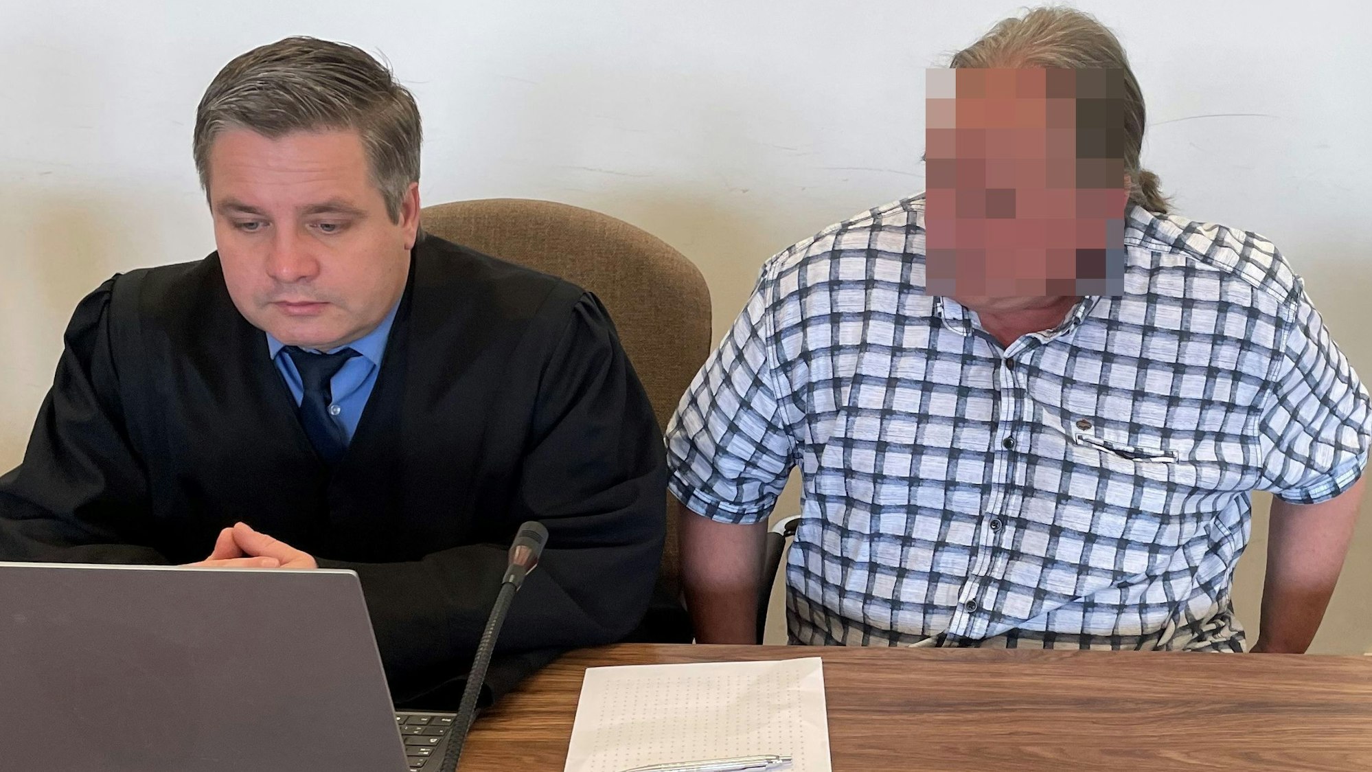 Der Angeklagte mit Verteidiger Sven Nelke im Prozess um einen Schießkugelschreiber in Köln