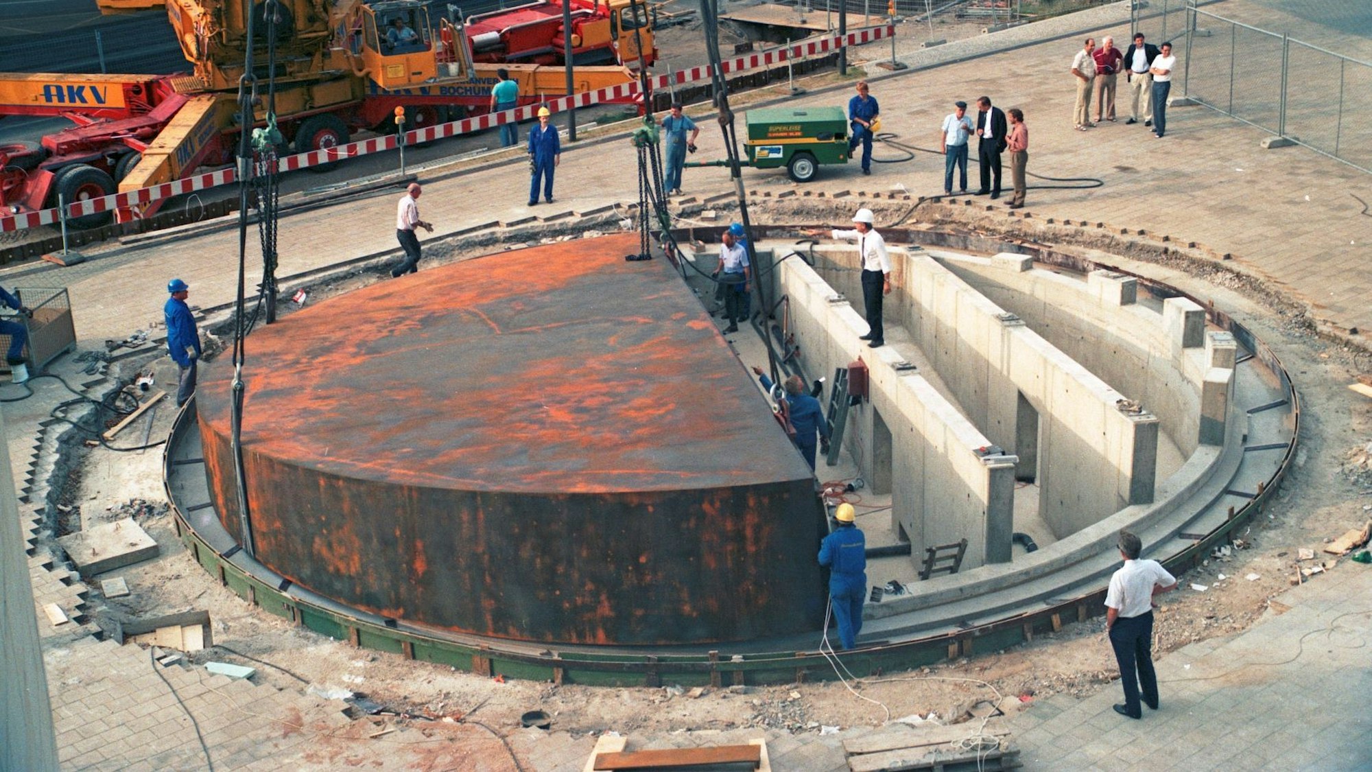 Arbeiter bauen das Fundament des Koloss vor dem Landtag. Im Hintergrund steht ein Kran, die Arbeiter stehen zwischen Betonmauern.