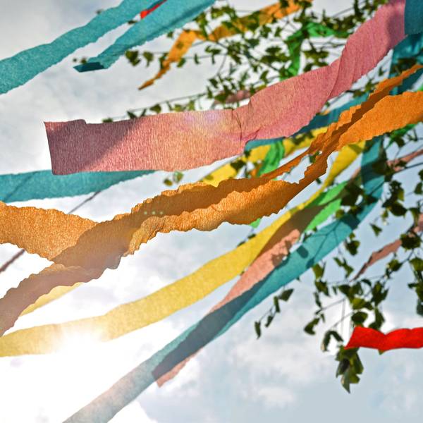 Bunte Bänder an einem Maibaum flattern im Wind.