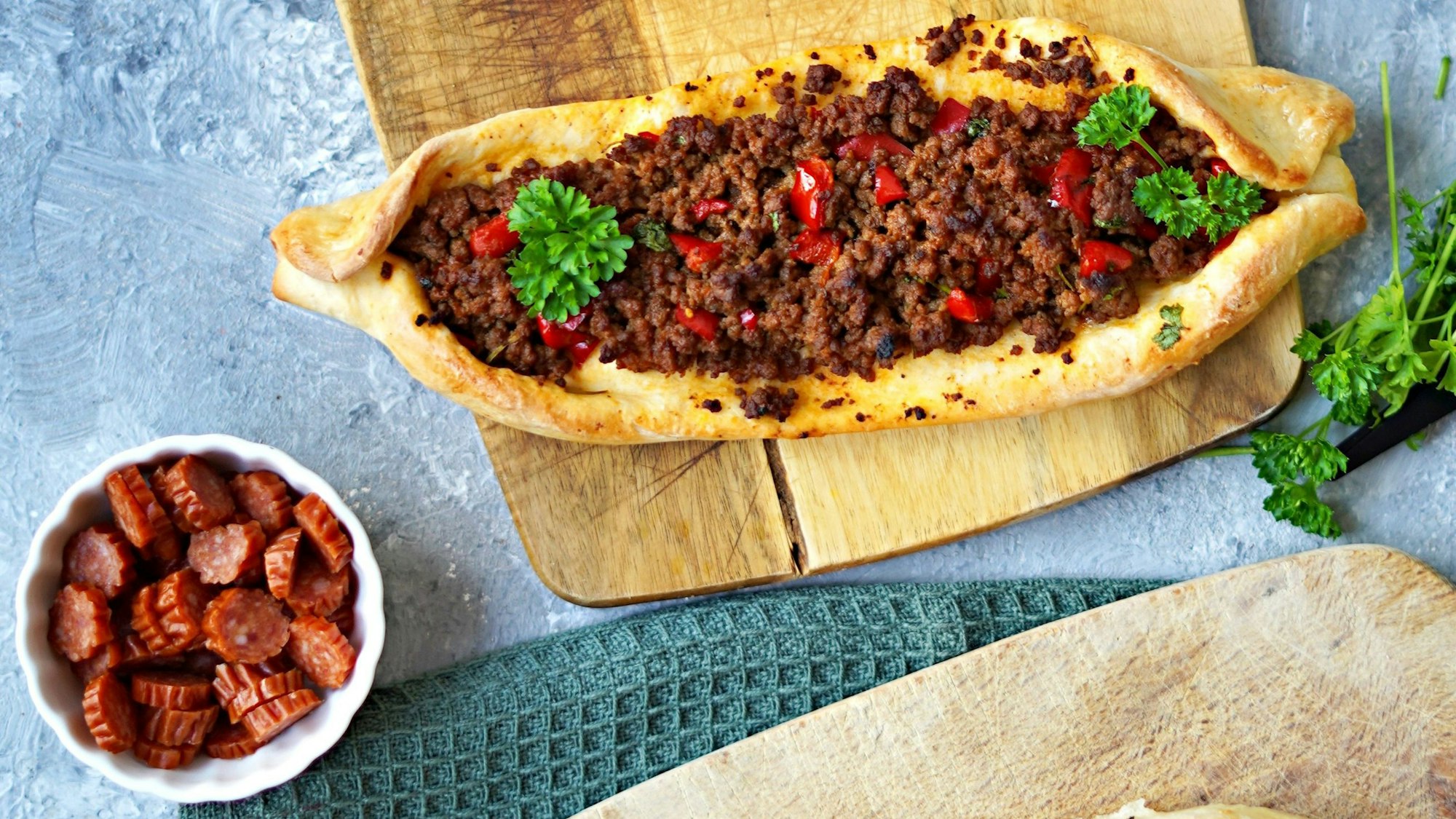 Fladenbrot-Schiffchen mit Käse und Kabanossiwurst und Paprika-Hackfleisch-Mischung