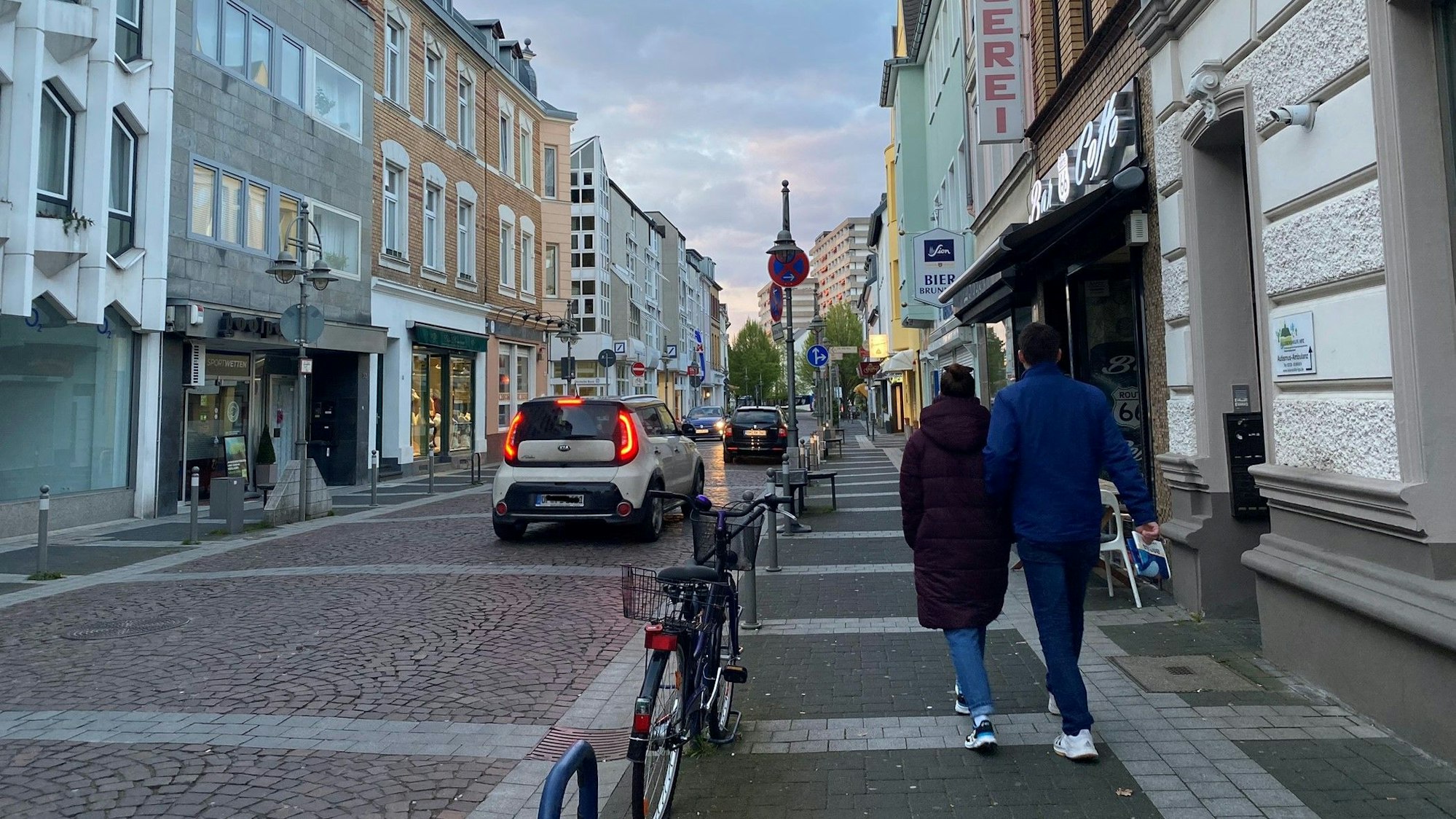 Das Foto zeigt die Kölnstraße in Brühl. Sie wird von mehreren Autos befahren, auf dem Bürgersteig gehen zwei Passanten.