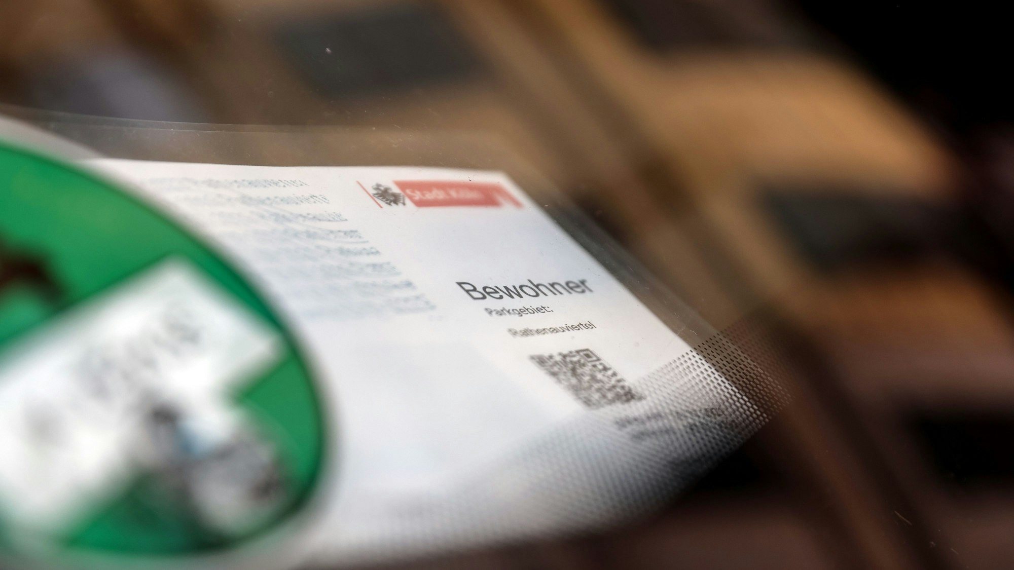Ein Bewohnerparkausweis liegt hinter einer Windschutzscheibe.