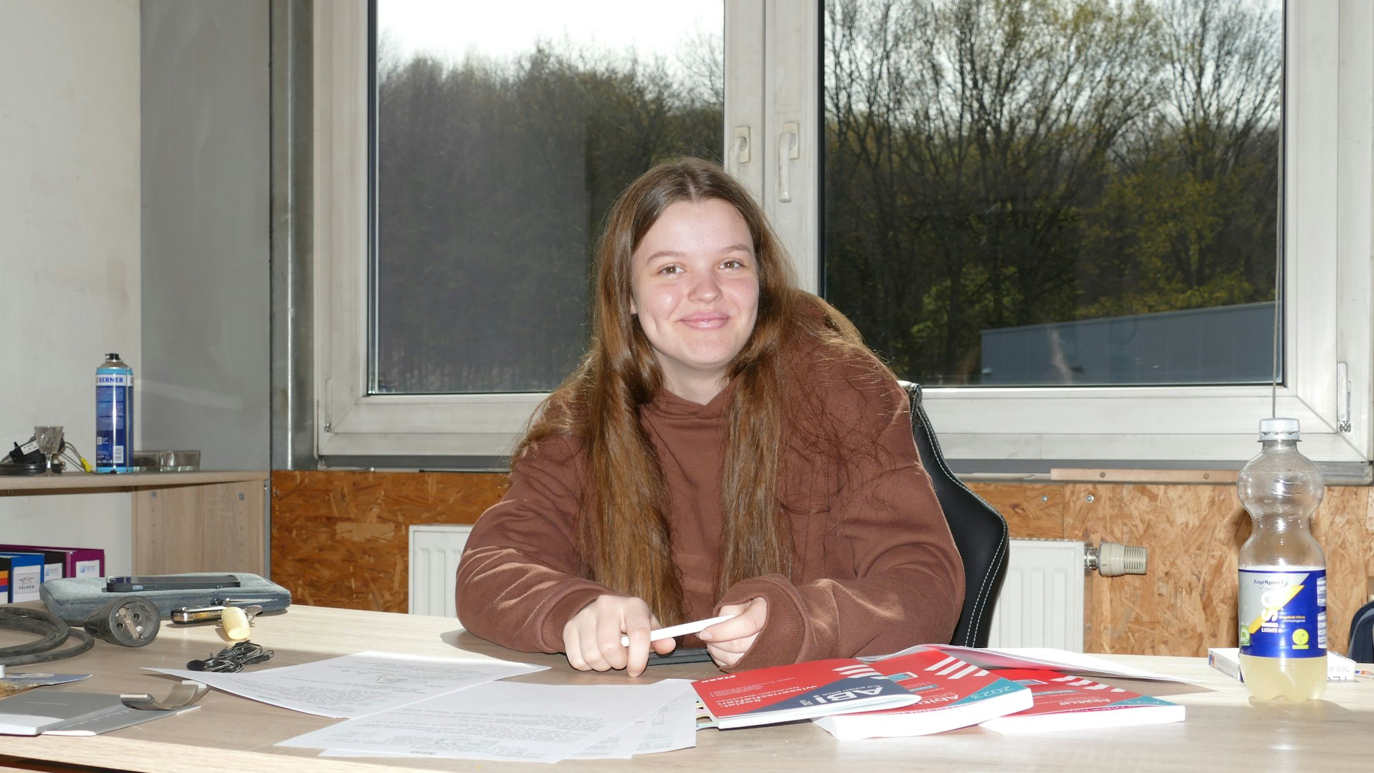 Eine junge Frau sitzt am Schreibtisch.