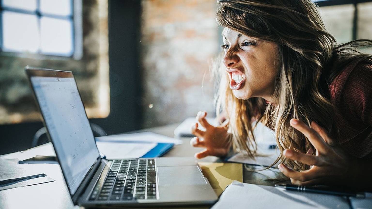 Frau vor dem Laptop die sich aufregt