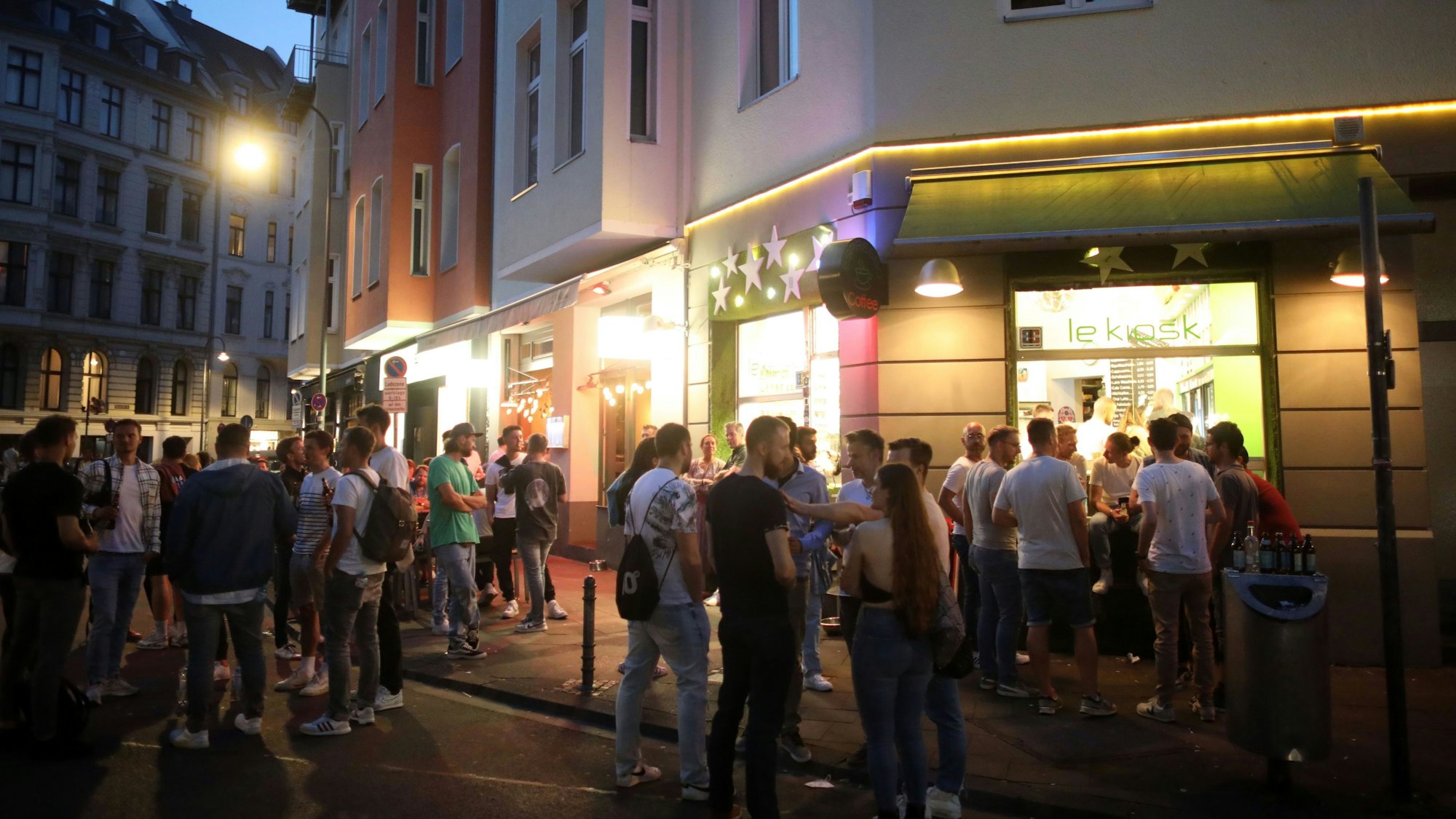 Menschen stehen an einem Kiosk am Brüsseler Platz.