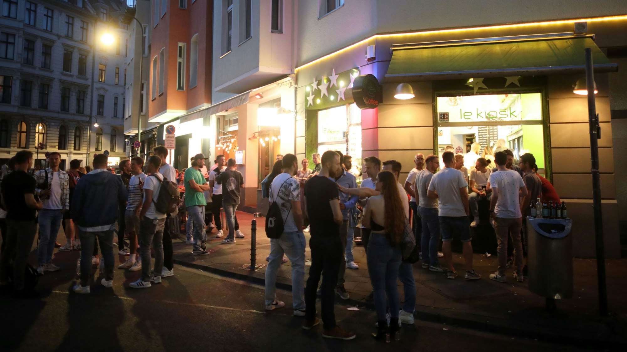 Menschen stehen Schlange an einem Kiosk am Brüsseler Platz.