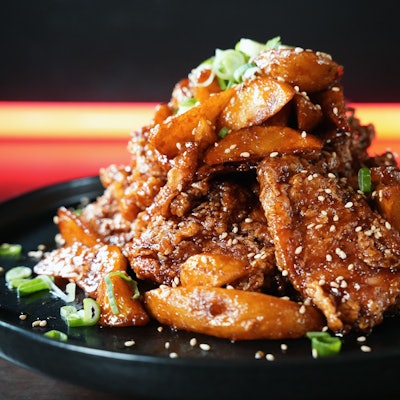 Hühnchen- und Kartoffelstücke sind auf einem Teller zu einem Berg drapiert