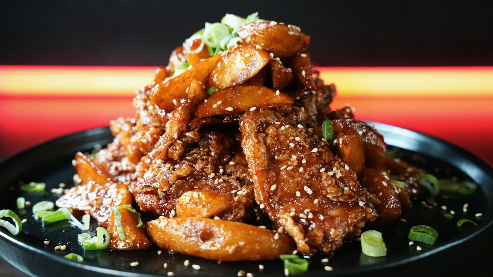 Hühnchen- und Kartoffelstücke sind auf einem Teller zu einem Berg drapiert