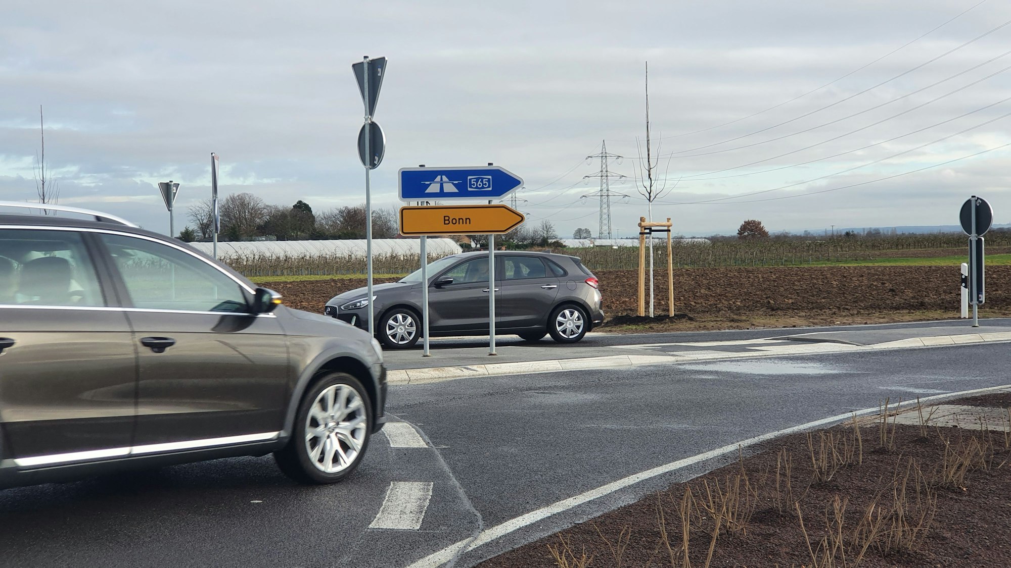 Zwei Autos an einem Abbiegeschild.