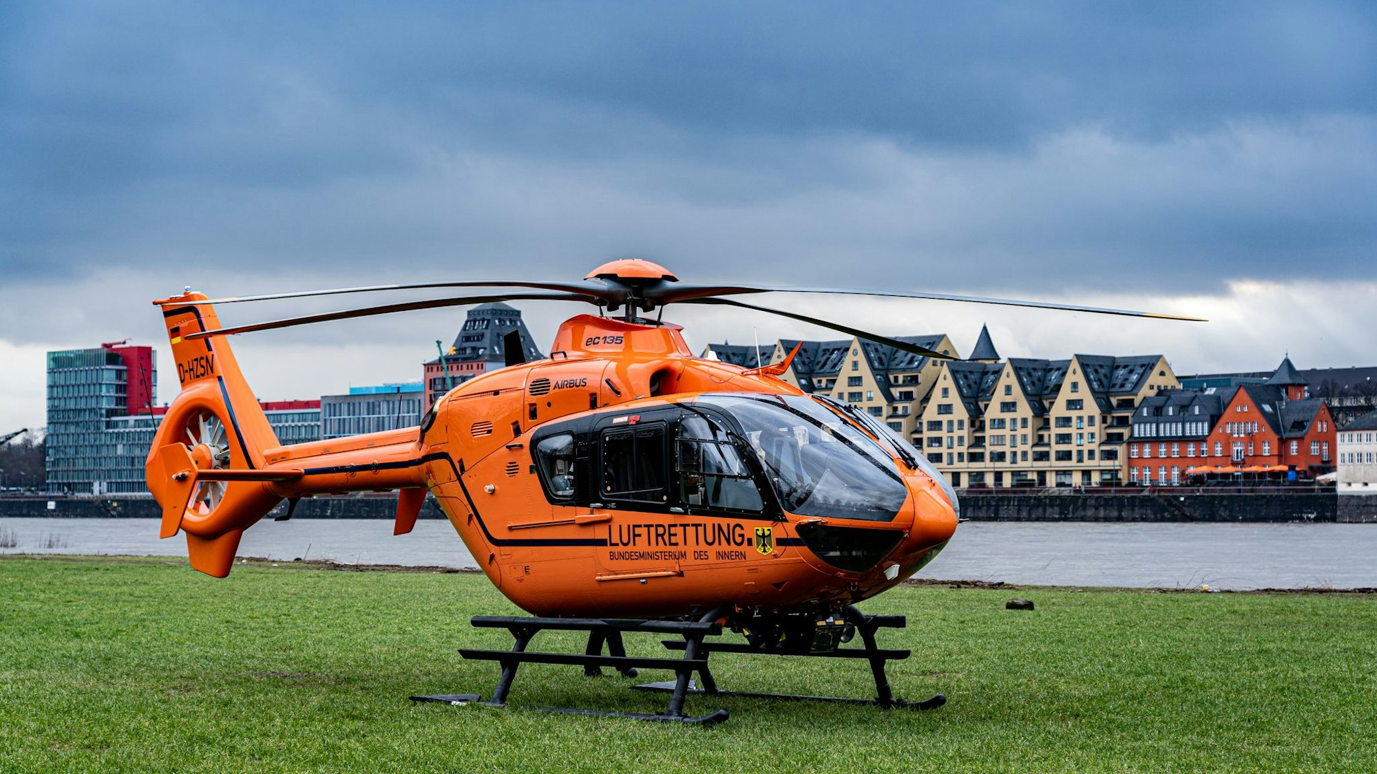 Der RTH vor dem Rhein auf einer Wiese.